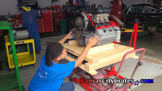 Crate Technician Lance checks placement of blocks placed under engine to support it during transport inside the custom solid wall wood vault crate