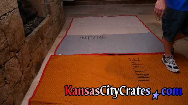 Fine stone floor with furniture blankets laid out before using area to wrap items for crates.