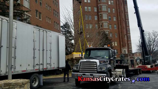 Belger-Cartage Crane truck lifts crate to top of Walnut apartments in Kansas City MO