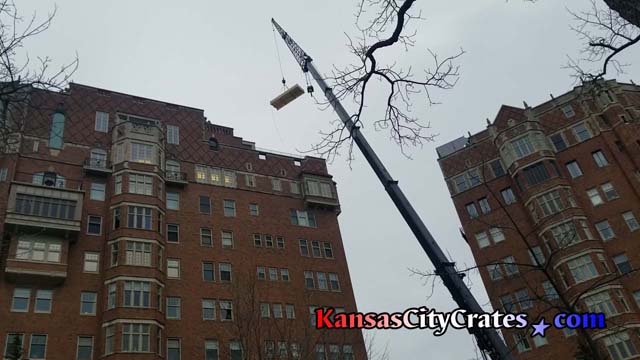 Belger-Cartage Crane truck lifts crate to top of Walnut apartments in Kansas City MO
