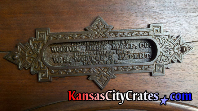 Close up photo of real solid bronze name plaque hardware on Wooton Cabinet Office Secretary desk. circa 1874