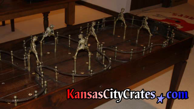 Antique court jesters made of brass on wood table before packing in crate.
