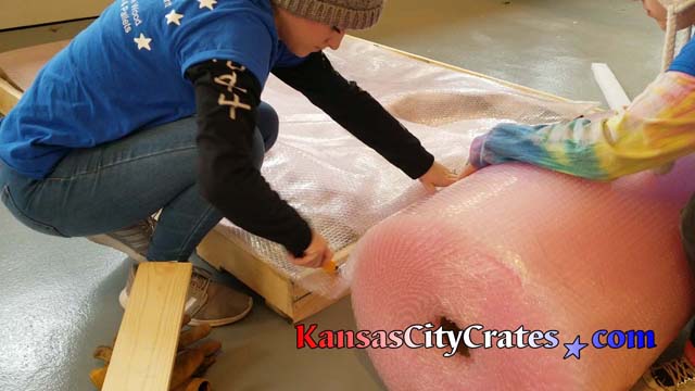 Kansas City Crates personnel cover wrapped artwork with bubblewrap before closing crate