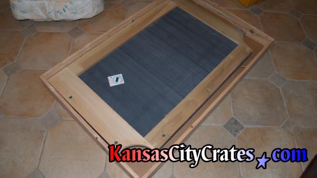Italian slate with wood frame laying on cardboard in slat crate before packing.