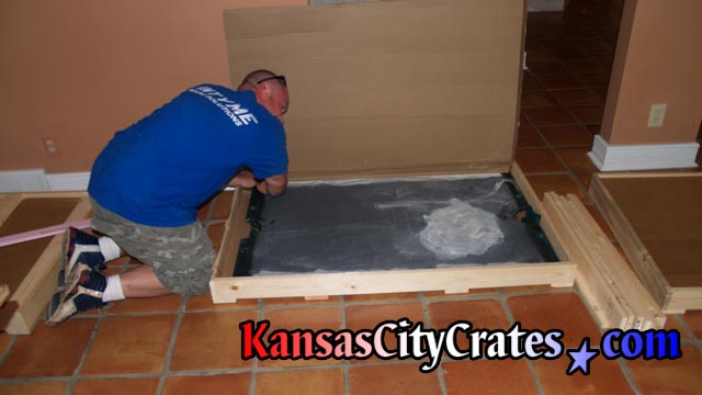 Positioning slate in crate before placing foam to protect corners.