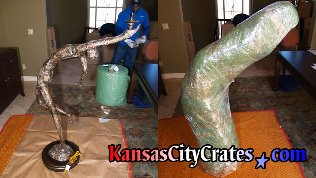 Two views of large bronze sculpture lamp of ballet dancer in performance stance before and after wrapping with paper pads, bubble and stretch wrap.
