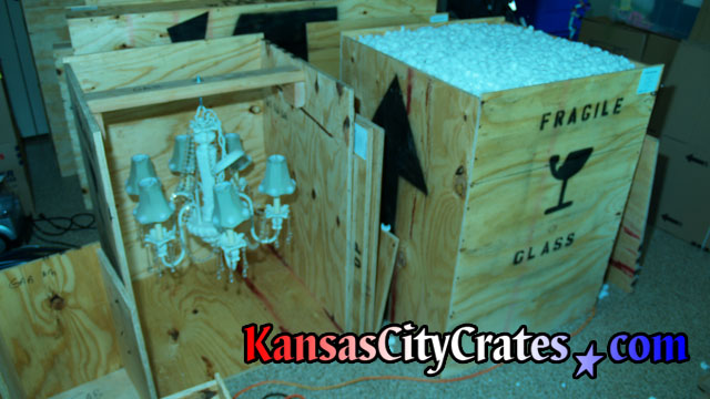 Two crates with fine porcelin chandeliers packed with foam peanuts for moving.