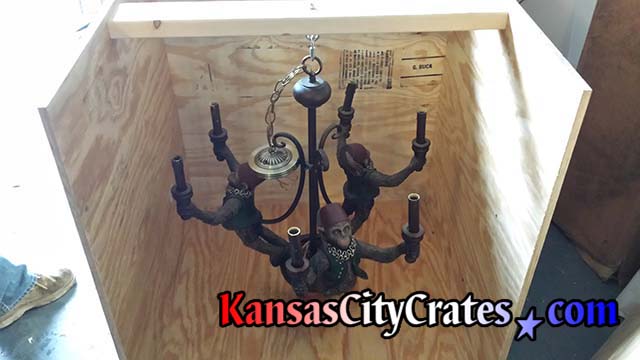 Chandelier removed from ceiling and haging on suspension hook in crate