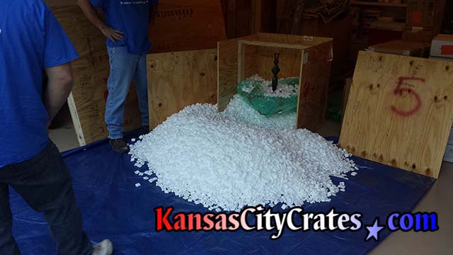 Crate is opened on large tarp to capture all the foam packing peanuts