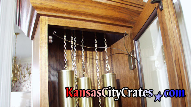 Security wire ran through chains holding clock weights before servicing movement to pack longcase cabinet into wood crate at home in Bonner Springs KS  66012