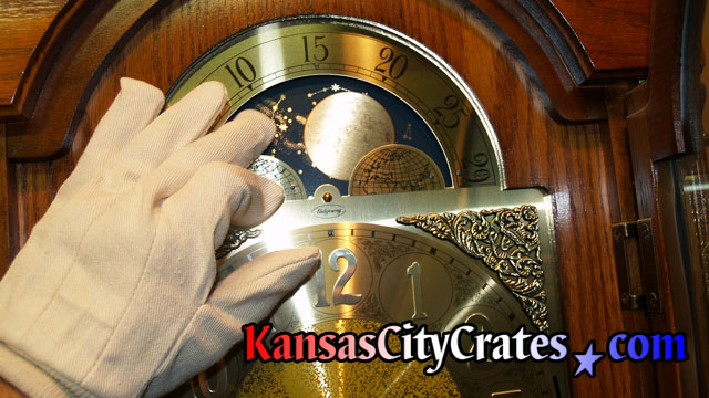 White gloves are used when touching brass parts of clock during crate company service.