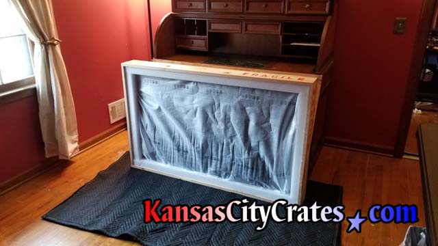 Anti-static screen protector placed over TV inside crate