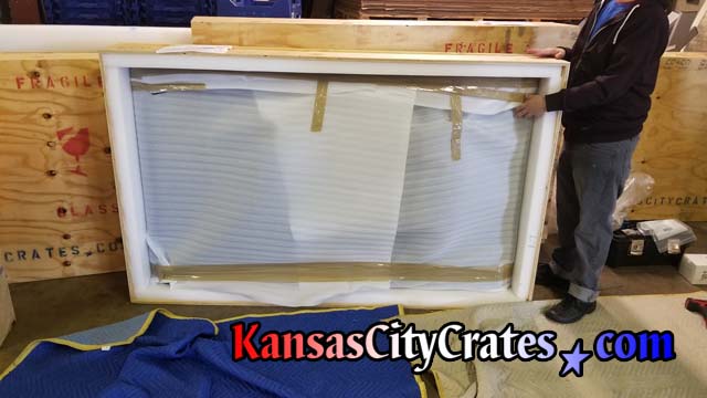 View of open crate with Smartboard television wrapped in anti-static foam