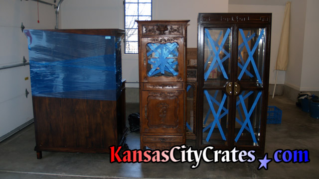 Original glass in cabinets are prepared for wrapping before crating of the furniture.