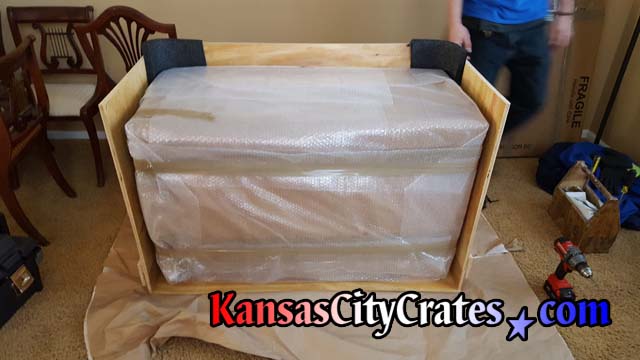 Foam corners protect antique drop leaf table inside solid wall vault like furniture crate