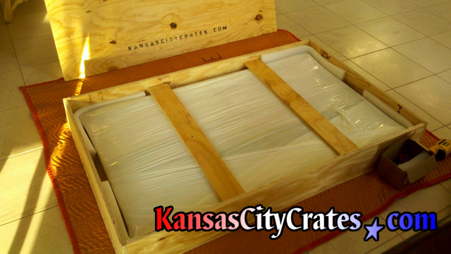 Cross members added to wooden box crate to hold mirror in place during shipping.