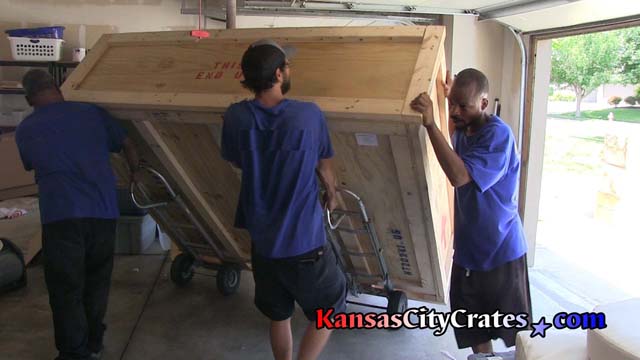 Expoct crate being moved on dollies by transportation specialists