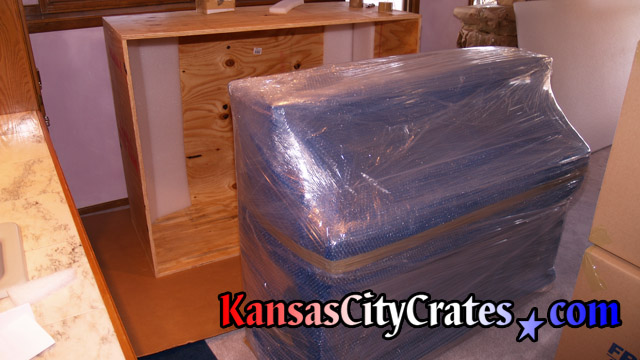 Paper wrapped, bubble wrapped and stretch wrapped Sauter piano before loading into export crate.