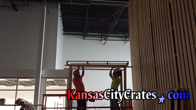 JE Dunn Construction employees raising pallet built by Kansas City Crates