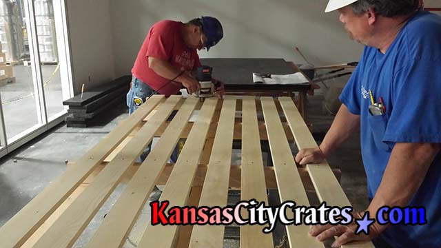 JE Dunn Construction employees adding lights to installing pallet built by Kansas City Crates for Helix Architecture and Design