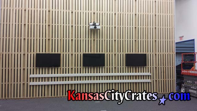 Flat screen monitors and projector mounted on pallet wall