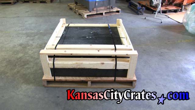 Granite machine top on rough oak pallet with open frame style crate steel strapped with double notch seals before stretch wrapping.