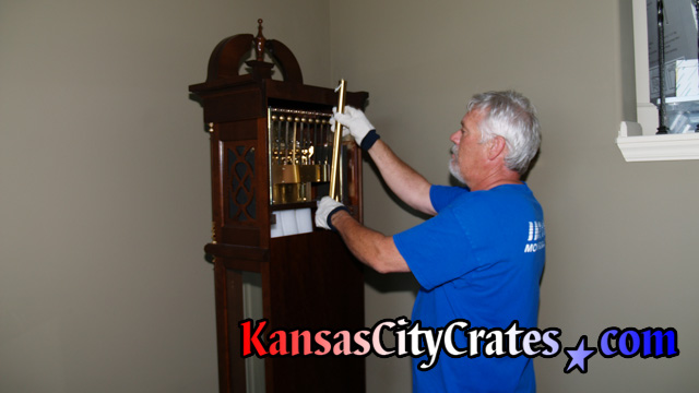 John removing tubular chime from back of clock